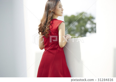 beautiful woman in red dress is seeing scene from balcony 31284816