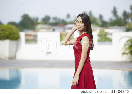 young girl strokes her hair beside the pool 31284840