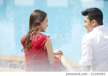 The couple is talking happily beside the pool 31284903