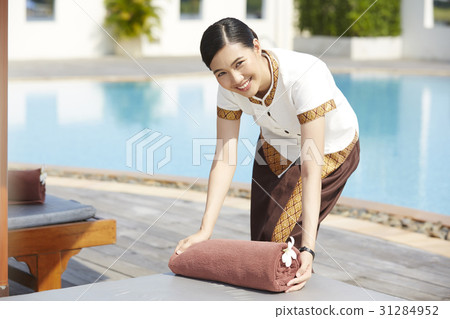 A photo of a maid smiling and serving at a pool of resort. A photo of a maid smiling and serving at a pool of resort. 31284952