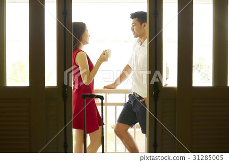 A couple is talking at a balcony of a hotel room. 31285005