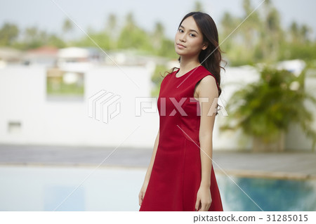 A portrait of beautiful woman in red dress standing and smiling . 31285015
