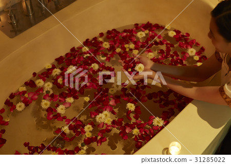 The maid is decorating bathtub with flowers in hotel. The maid is decorating bathtub with flowers in hotel. 31285022