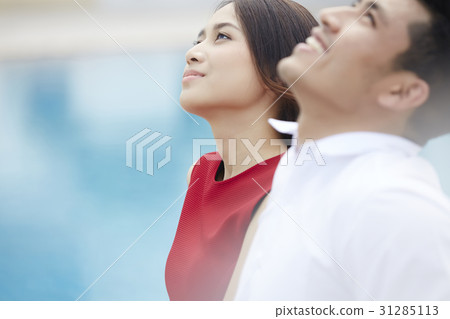 the couple is smiling and seeing at the sky. 31285113