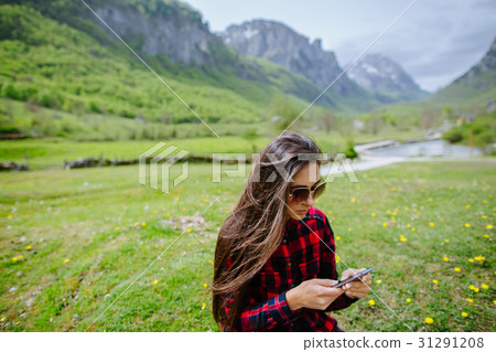 woman with smartphone backpacking in mountains woman with smartphone backpacking in mountains 31291208