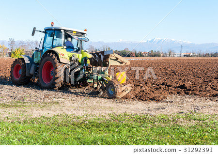 Tractor plowing a field 31292391