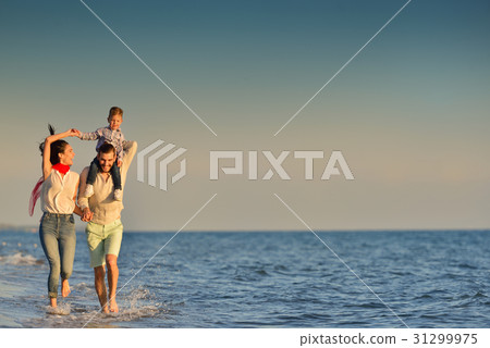 happy young family have fun on beach run and jump 31299975