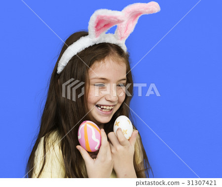 Kid with a bunny hairband holding eggs Kid with a bunny hairband holding eggs 31307421