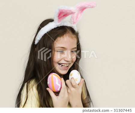 Kid with a bunny hairband holding eggs Kid with a bunny hairband holding eggs 31307445