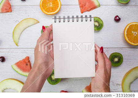 Top view of girl's hands, placed on white desktop 31310369