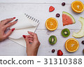Top view of girl's hands, placed on white desktop 31310388