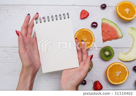 Top view of girl's hands, placed on white desktop Top view of girl's hands, placed on white desktop 31310402