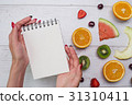 Top view of girl's hands, placed on white desktop 31310411
