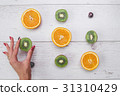 Top view of girl's hands, placed on white desktop 31310429