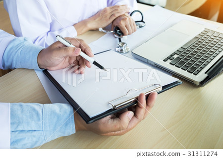 Two doctors discussing patient notes in an office 31311274