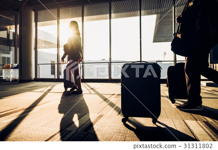 Silhouette of woman walking with luggag at airport 31311802