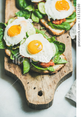 Healthy breakfast sandwiches on wooden board over Healthy breakfast sandwiches on wooden board over 31312280