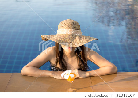 Happy smiling woman with straw hat in swimming poo Happy smiling woman with straw hat in swimming poo 31315107