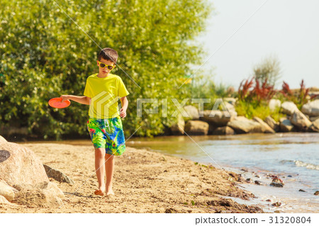 Little boy playing with frisbee disc. 31320804