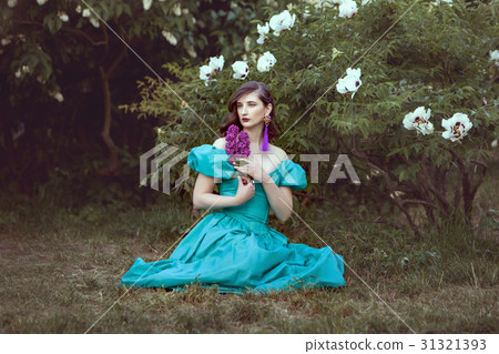 Woman with a lilac sits on the grass. Woman with a lilac sits on the grass. 31321393