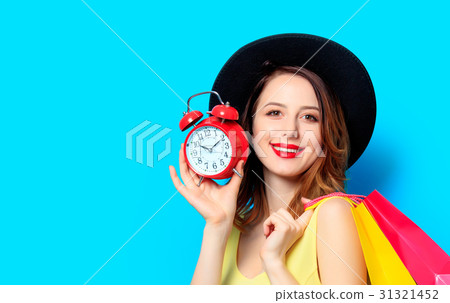 Woman with alarm clock and shopping bags Woman with alarm clock and shopping bags 31321452