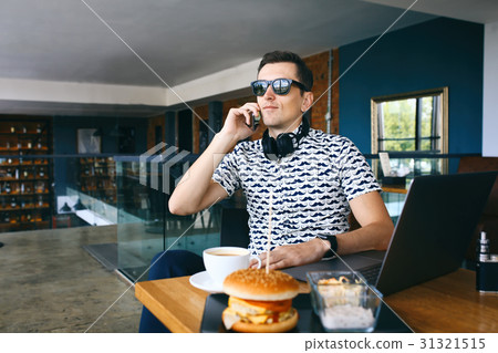 Young handsome hipster man in sunglases sitting in 31321515