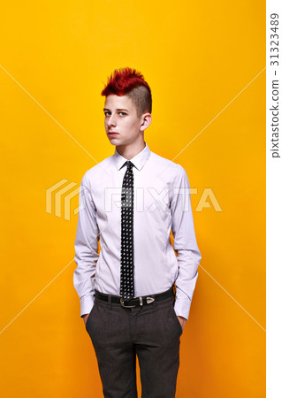 Fashionable teen with red mohawk looking away Fashionable teen with red mohawk looking away 31323489