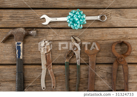 Wrench with ribbon by hand tools on wooden table Wrench with ribbon by hand tools on wooden table 31324733