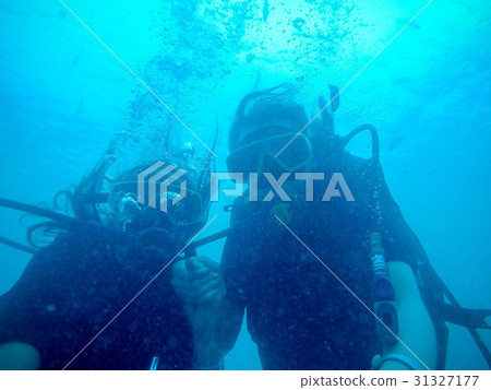 Women scuba divers exploring underwater life in Women scuba divers exploring underwater life in 31327177