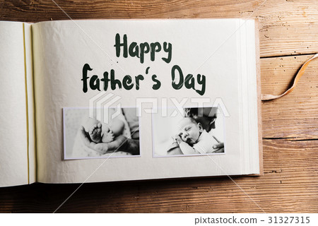 Photo album with pictures of father and baby son 31327315