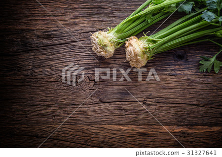Fresh celery root with leaf on rustic oak table. Fresh celery root with leaf on rustic oak table. 31327641