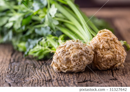 Fresh celery root with leaf on rustic oak table. Fresh celery root with leaf on rustic oak table. 31327642