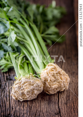 Fresh celery root with leaf on rustic oak table. Fresh celery root with leaf on rustic oak table. 31327643