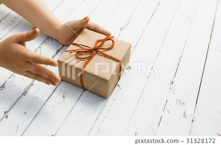 Craft paper gift box with red bow in the children Craft paper gift box with red bow in the children 31328172