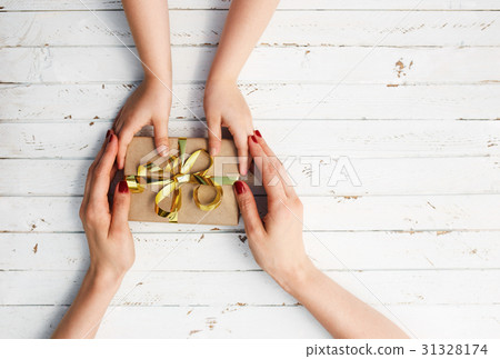 Woman with her child holding a gift in hand on 31328174