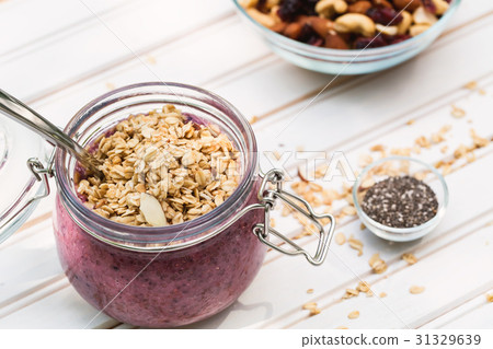 Smoothie topped with granola in a mason jar 31329639