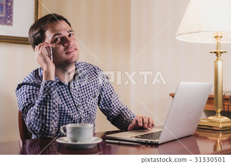 Young happy man talking on the phone at his 31330501