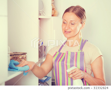 Positive woman wiping shelves Positive woman wiping shelves 31332824