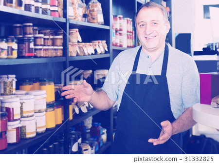 salesman working in delicatessen section of ordinary grocery 31332825