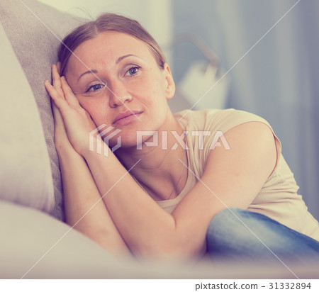 Sad woman sitting on sofa 31332894
