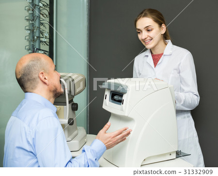 female ophthalmologist and mature patient checking eyesight in clinic female ophthalmologist and mature patient checking eyesight in clinic 31332909