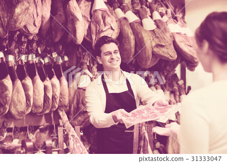 Cute cheerful brunette choosing iberico and serrano jamon Cute cheerful brunette choosing iberico and serrano jamon 31333047