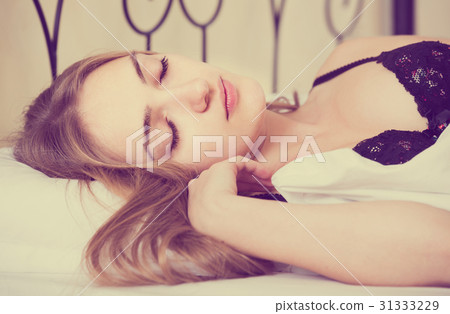 woman lying in bed under sheet with closed eyes woman lying in bed under sheet with closed eyes 31333229