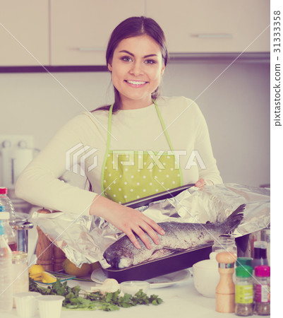 girl putting salmon fish in tray for baking girl putting salmon fish in tray for baking 31333358