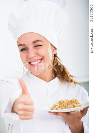 Girl cook shows plate of porrige Girl cook shows plate of porrige 31333506