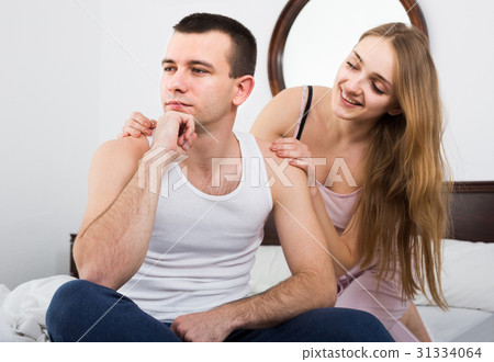 wife warmly comforting upset husband in bedroom 31334064