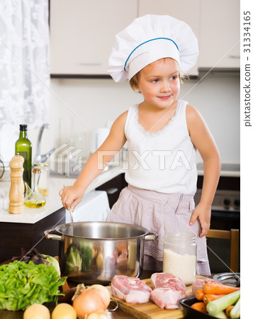 baby girl in cook hat cooking soup 31334165