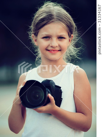 Girl taking pictures with professional camera outdoors Girl taking pictures with professional camera outdoors 31334167