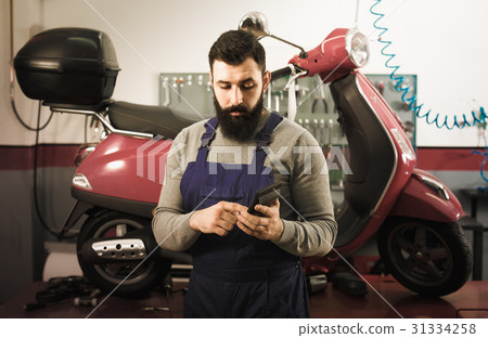 Worker counting sum for his repairing motorcycle 31334258