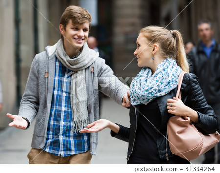 Nice-looking male student chasing pleased girl on outdoor date Nice-looking male student chasing pleased girl on outdoor date 31334264